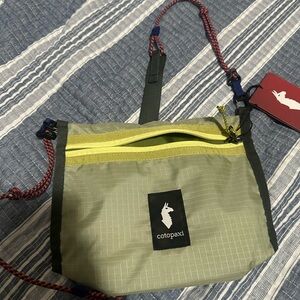 cotopaxi light green crossbody with yellow zipper and navy accents